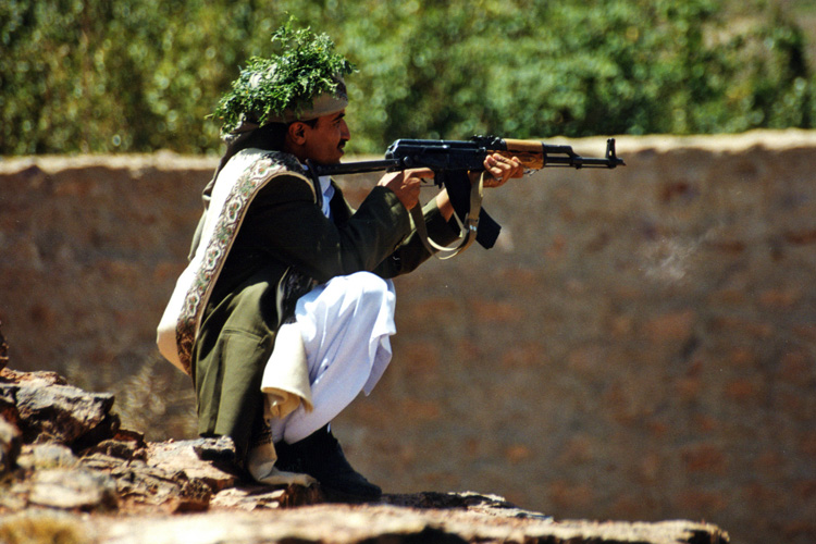 Yémen, homme tirant à la kalachnikow, sur les hauteurs du Whadi Dhar, aux environs de Sanaa