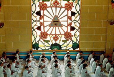 Recueillement sous l'oeil divin, symbole du Caodaïsme, durant la messe de midi. Temple Cao Dai de Tay Ninh, Vietnam, 1997